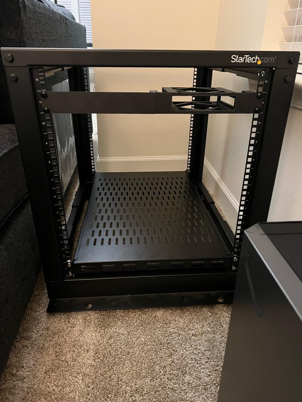 StarTech 1U 4-Post Vented Rack Shelf, 28-34.4in, 150lb (ADJSHELFV-Rack) | Adjustable depth 71.1-87.3cm, 150lb/68kg capacity, Cold-rolled steel, M5 hardware customer photo 1